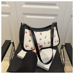 Detail of cherry print shoulder bag with black trim and elegant chain strap detail