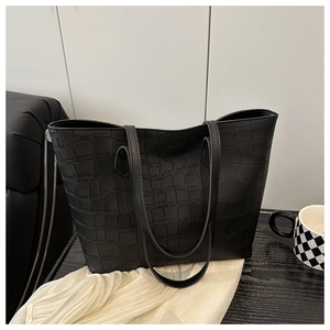 Close-up of black crocodile embossed leather texture on large tote bag for women
