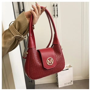 Détail du sac rouge en cuir montrant la texture tressée et le fermoir doré logo M