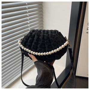 Detailed view of black leopard print shell bag with elegant faux pearl handle and gold hardware