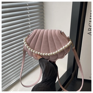 Detail of pink shell-shaped crossbody bag with pearl strap and matte textured finish