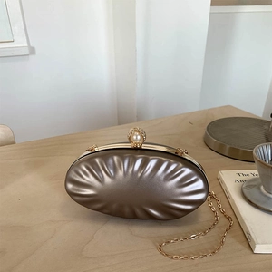 Elegant champagne gold shell-textured evening clutch bag with pearl clasp and chain