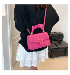 Detail of rose pink quilted crossbody bag with golden square lock and ruched handle