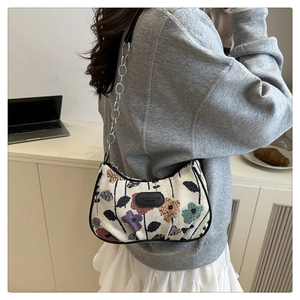 Dettaglio della borsa a spalla in maglia floreale con catena in metallo e inserto in pelle