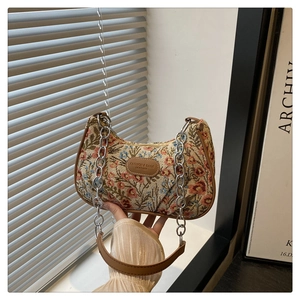 Dettaglio della borsa hobo in jacquard floreale con bordi in pelle e tracolla a catena