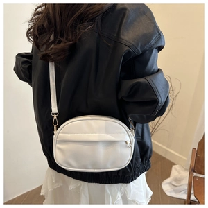 Vue arrière d'un sac bandoulière en cuir blanc avec poche zippée sur un mannequin