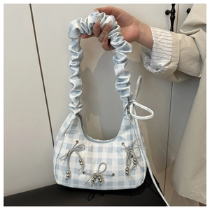 Detail view of light blue checkered cloud bag with pleated strap and bow accents