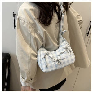 Detail of light blue gingham bag featuring small cord bows and metallic bead accents