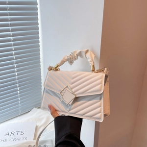Elegant white quilted crossbody bag with golden buckle and ruffled top handle for women