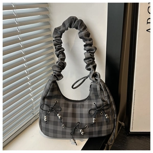 Detailed view of the plaid fabric texture, ruched handle, and decorative ribbon bows