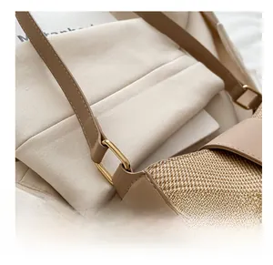Close-up of golden metal ring buckle connecting khaki leather and woven fabric strap