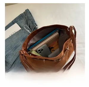 Vue macro de l'intérieur spacieux du sac cabas en daim marron avec accessoires