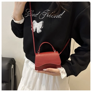 Détail du mini sac bandoulière rouge à motif crocodile avec poignée et fine lanière