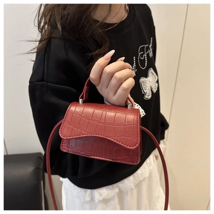 Detail of red croc-embossed mini square bag with silver hardware and asymmetric flap