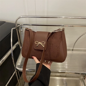 Brown vintage faux leather and suede shoulder bag with a gold bow metal buckle