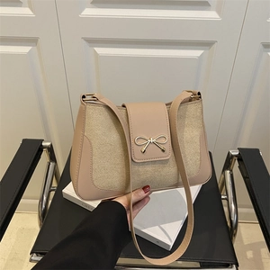 Minimalist beige shoulder bag with golden bow buckle and canvas leather texture