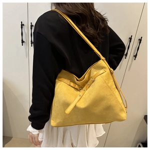 Detailed view of the ginger yellow suede tote bag shown on model for size and drape reference