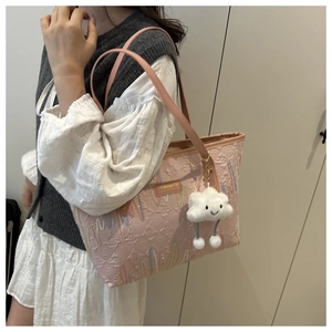 Dettaglio borsa tote rosa con ricami ondulati colorati e ciondolo a nuvola soffice