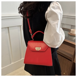Classic red trapezoid crossbody bag featuring an elegant gold-toned metal twist lock closure