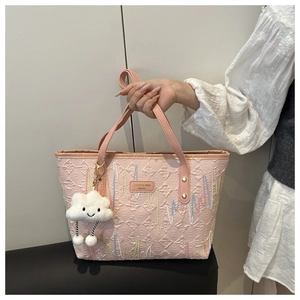Ricamo dettagliato e ciondolo a nuvola di peluche su questa borsa tote rosa trapuntata