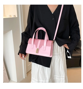 Détail du sac à main rose montrant la texture tissée et la boucle en métal doré de près