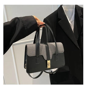 Detail of contrast plaid texture and gold metal turn-lock on the women's handbag