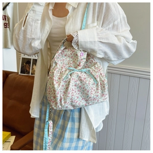 Detail of floral tote bag showing pink flower pattern and blue checkered drawstring bow