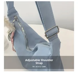 Detail of adjustable wide shoulder strap with silver buckle on light blue handbag