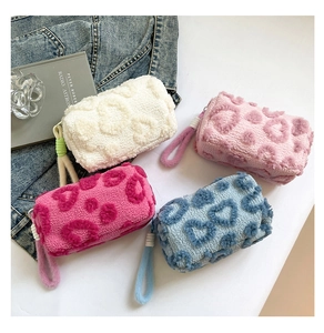 Detalle de neceseres de peluche con diseño de corazones en varios colores y textura suave
