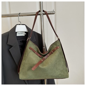 Vue détaillée du sac cabas vert foncé mat avec lanières en cuir marron et œillets en métal