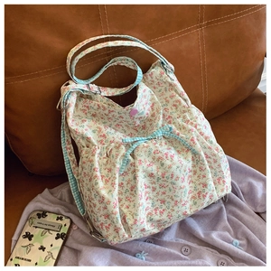 Detailed shot of floral canvas bag featuring pink patterns and a blue checkered bow tie