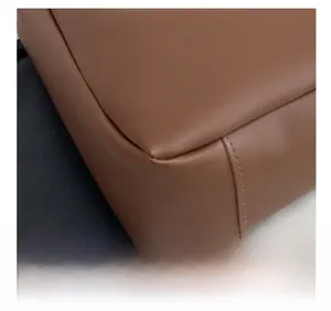 Close-up of precise stitching and premium leather texture on brown bucket bag corner