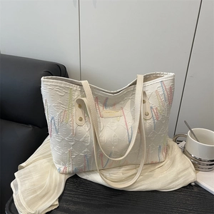 Minimalist white tote bag with embossed E-pattern and colorful wave embroidery
