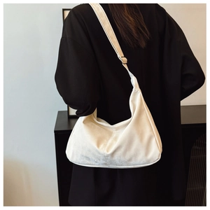 Detail of white velvet crescent hobo bag with adjustable silver buckle on a model