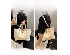 Detail of beige monogram tote bag showing both handheld and shoulder carrying options