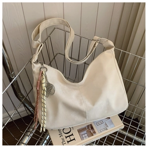 Detail of cream nylon tote bag with unique woven pendant in a silver basket