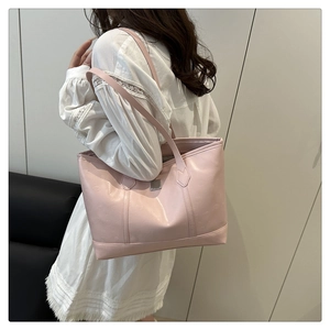 Detailaufnahme der rosa Leder-Tragetasche mit runder Musterprägung und schmalen Riemen