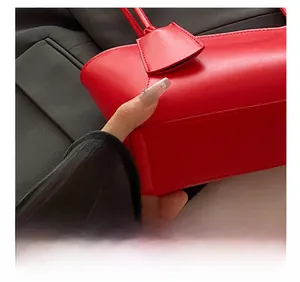 Détail des coutures précises et de la texture du cuir synthétique du sac fourre-tout rouge