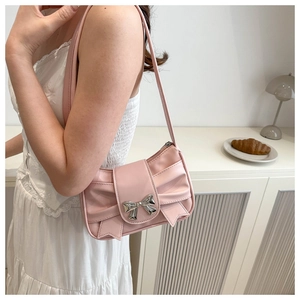 Vue détaillée du sac à bandoulière rose avec plis noeuds et boucle argentée