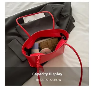 Vue intérieure du cabas en cuir rouge montrant sa grande capacité avec des objets personnels
