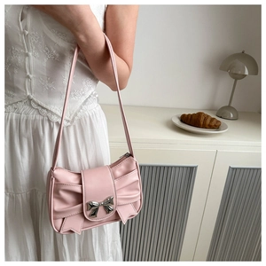 Détail du sac bandoulière rose avec plis en cuir et une boucle en métal argenté