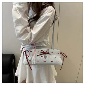 Détail du sac à main bleu clair avec pendentif cœur et bandoulière en dentelle fine