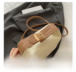 Detail of elegant gathered fabric and tan leather stitching with gold metal hardware buckle