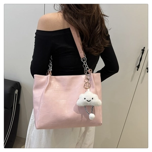 Rosa Tote Bag mit geometrischer Textur und Wolkenanhänger an der Schulter getragen