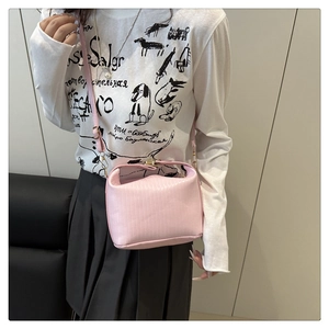Detail of pink mini crossbody bag with vertical stripe texture and gold clasp detail
