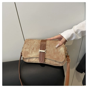 Close-up of vintage brown shoulder bag with signature gold H buckle and leather strap