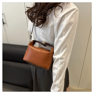 Detail of pleated texture and two-tone brown PU leather crossbody bag with metal buckle