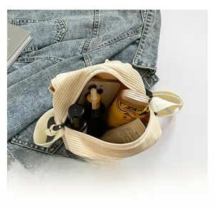 Internal view showing storage capacity of the cream corduroy crossbody bag