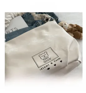 Close-up of the stylish white handbag featuring bear print and textured PU leather