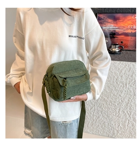 Détail du sac bandoulière en velours côtelé vert avec tirette de fermeture éclair tissée